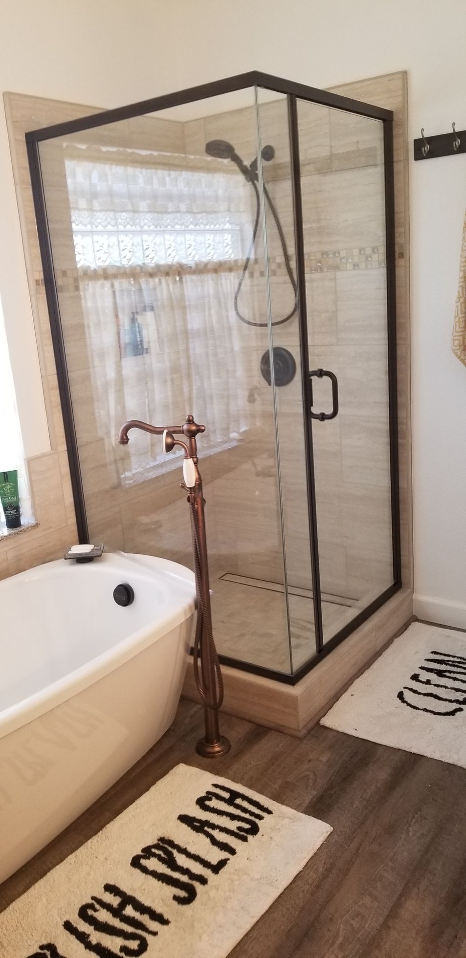 A bathroom with a bathtub , shower , and rug.