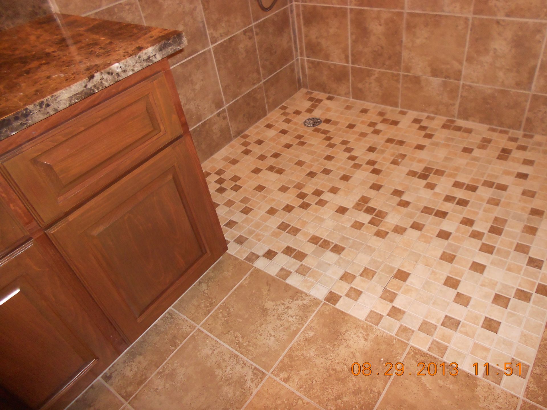 A bathroom with a walk in shower and wooden cabinets.