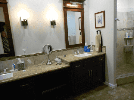 A bathroom with two sinks a mirror and a walk in shower