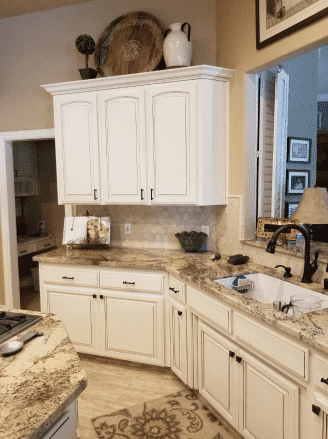 A kitchen with white cabinets and granite counter tops