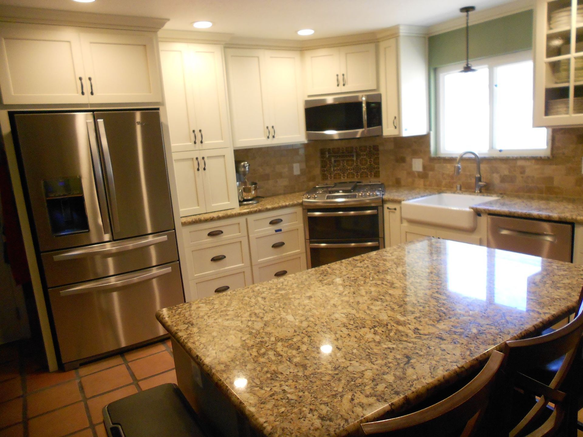 A kitchen with granite counter tops and stainless steel appliances