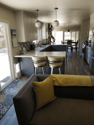 A living room with a couch and a kitchen in the background.