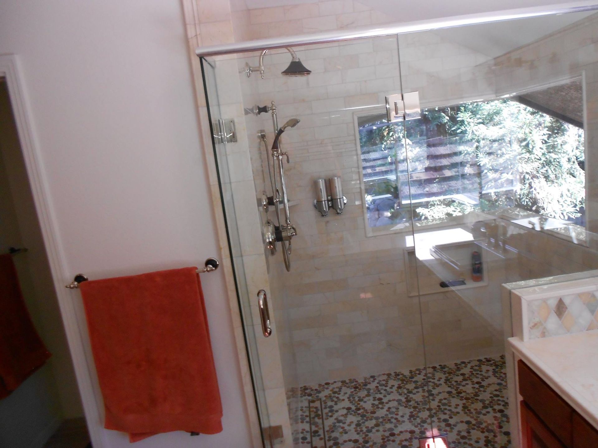 A bathroom with a walk in shower and a window