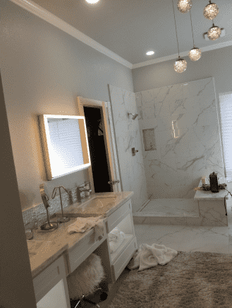 A bathroom with two sinks and a walk in shower.