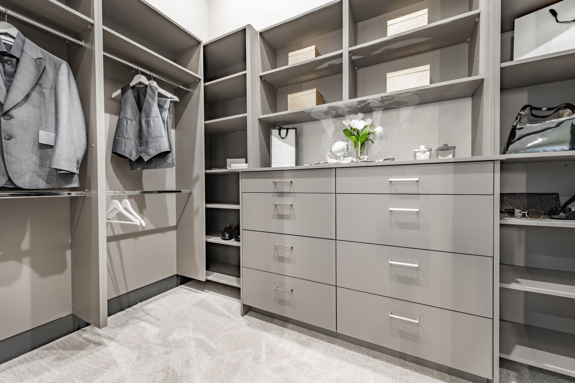 A walk in closet with lots of shelves and drawers.