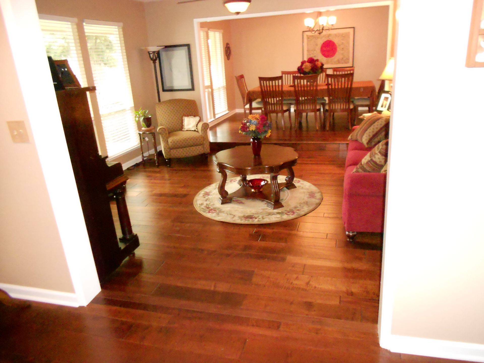 A living room with hardwood floors leading to a dining room