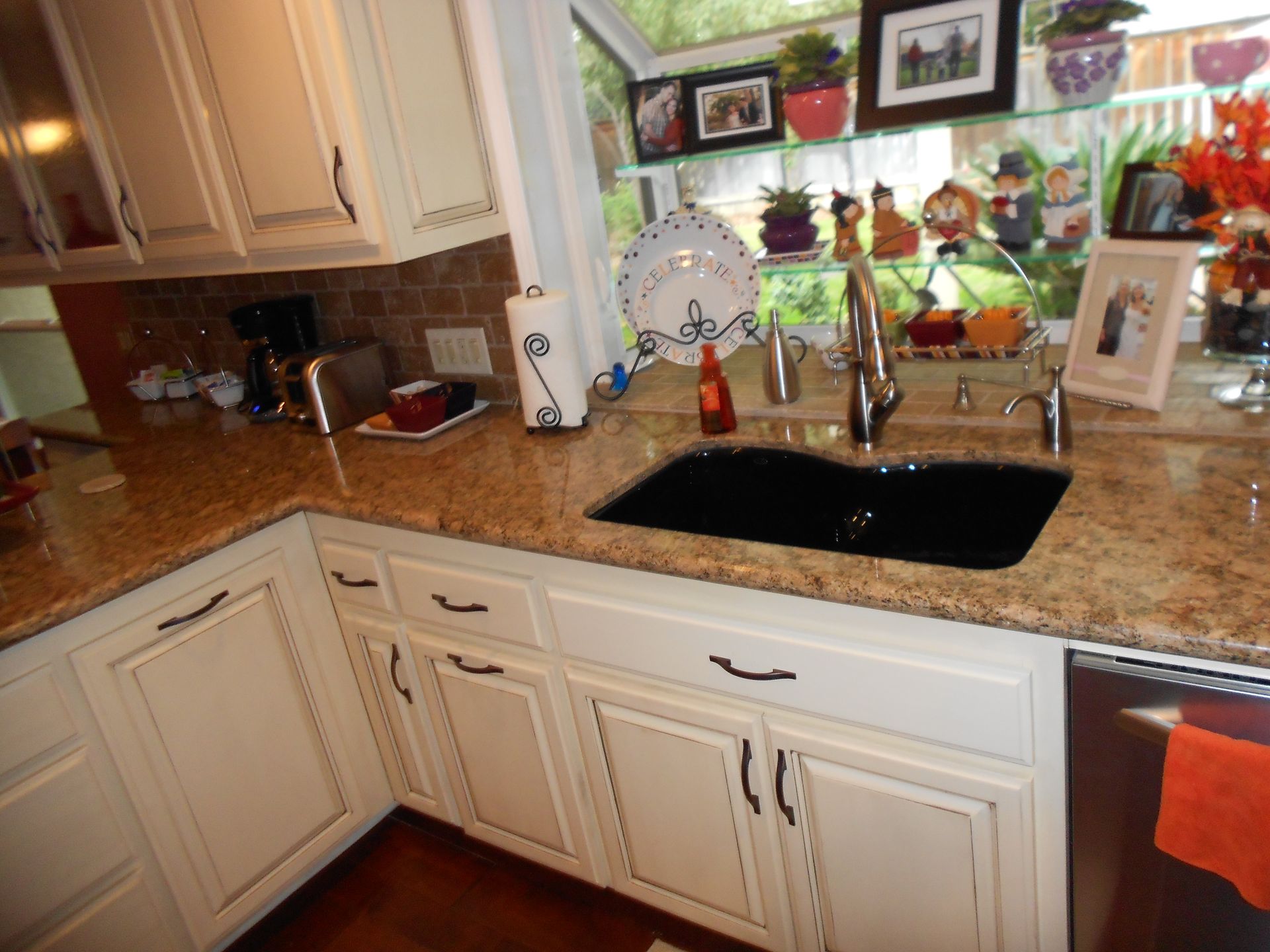 A kitchen with white cabinets and a black sink