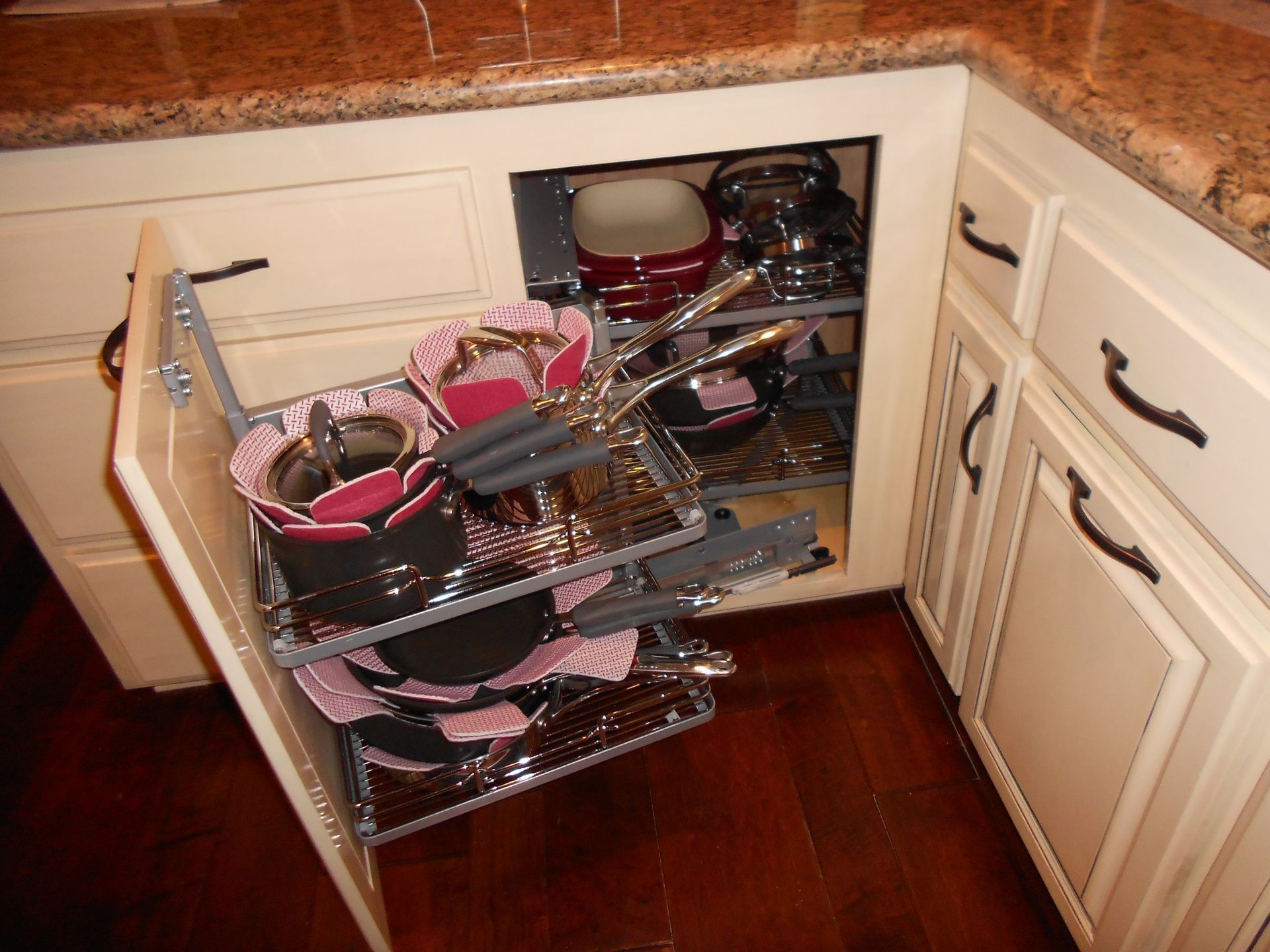 A kitchen cabinet with pots and pans in it