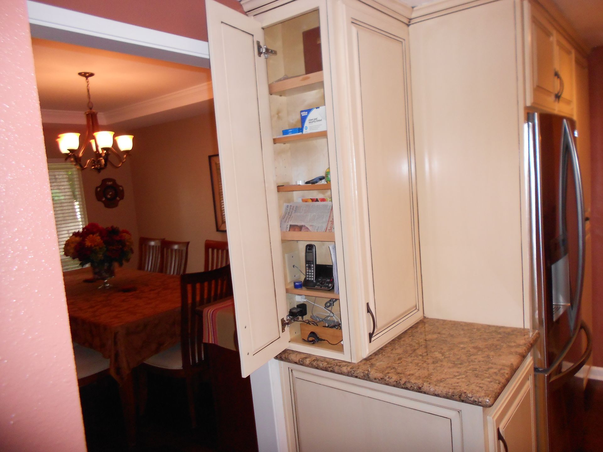 A kitchen with a pantry and a dining room in the background