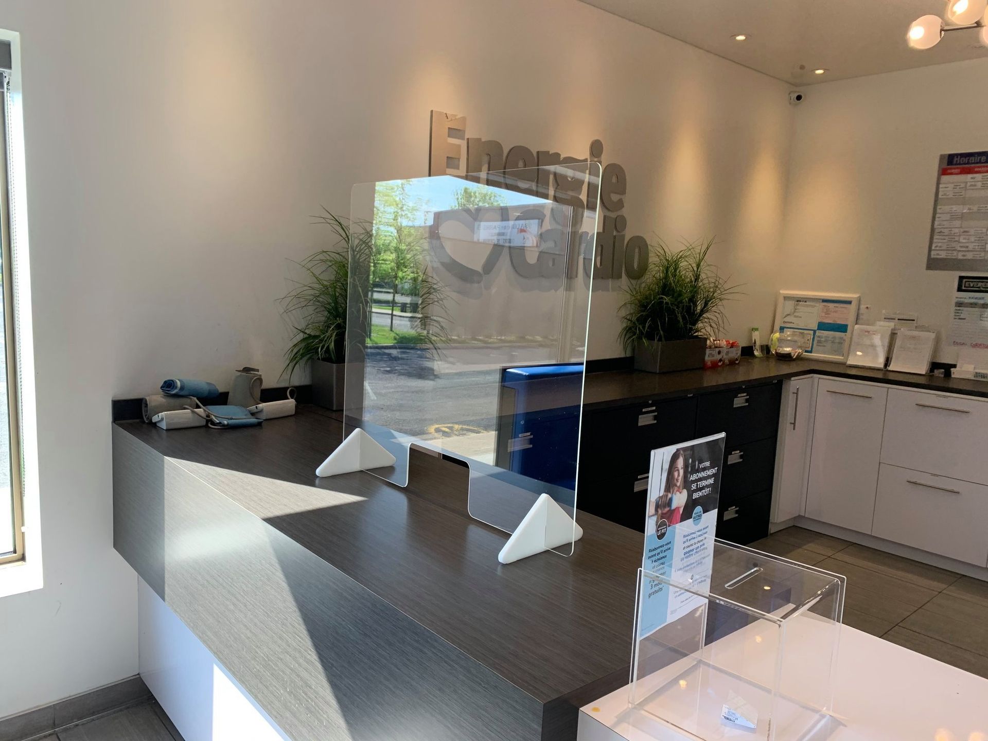 A reception desk with a clear acrylic divider in front of it.