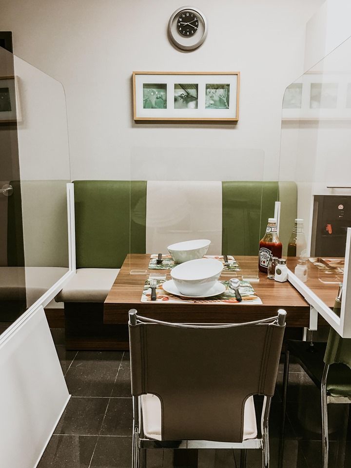 A dining room with a table and chairs and a clock on the wall
