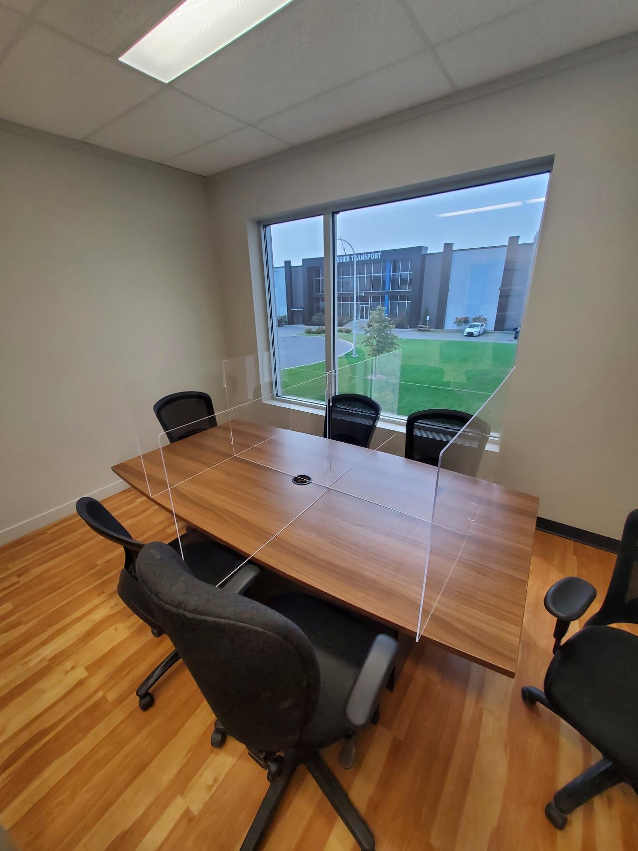 A conference room with a table and chairs in front of a large window.