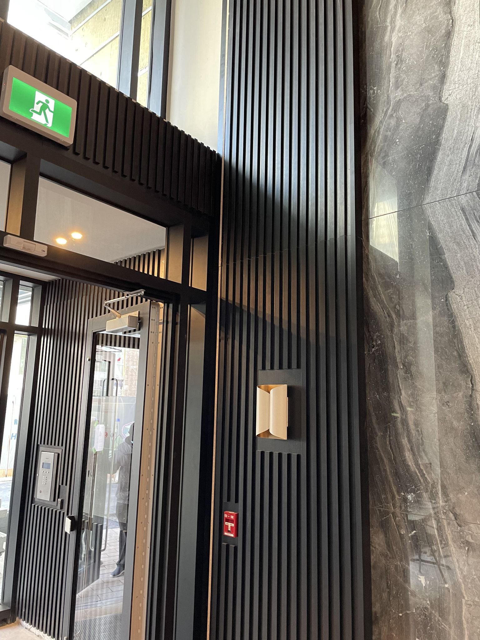 A large building with a green exit sign on the wall.