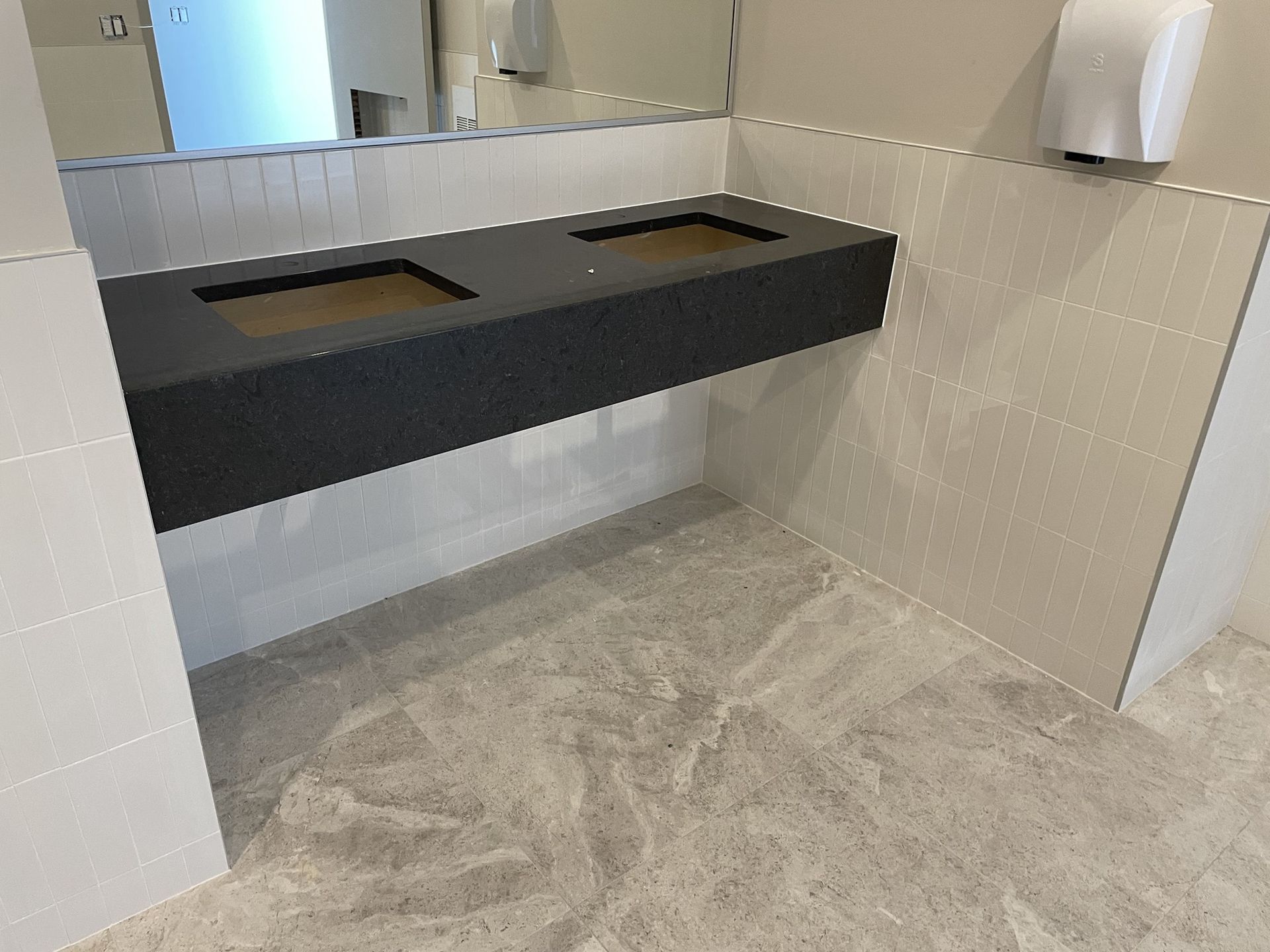 A bathroom with two sinks and a mirror