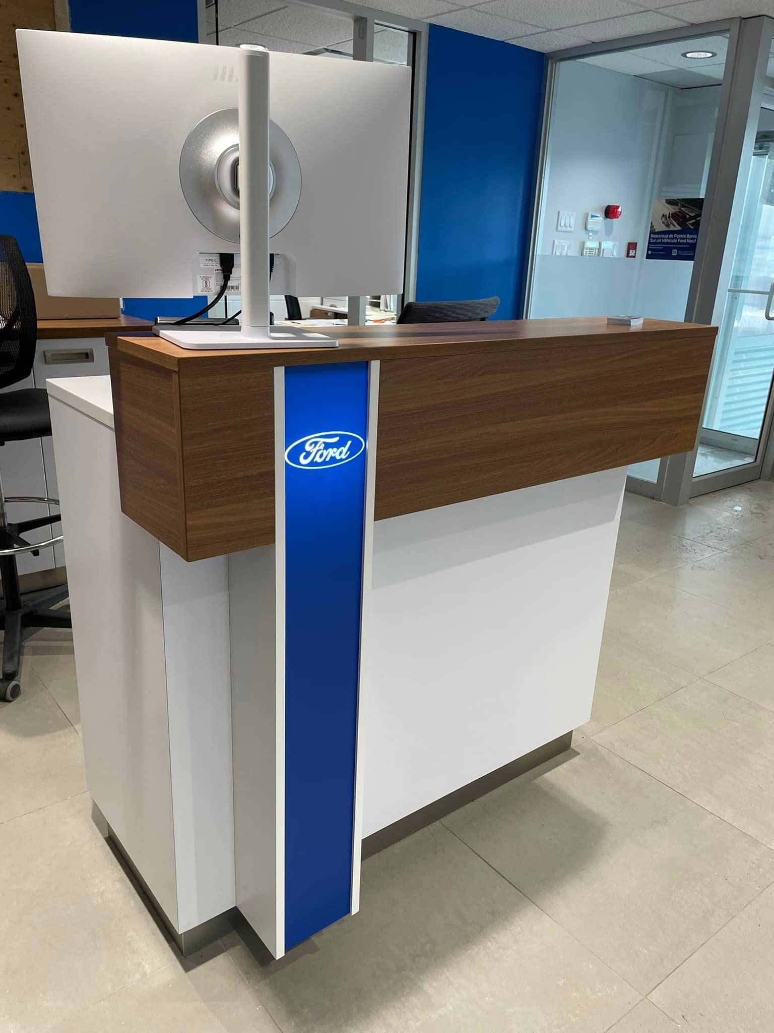 A ford reception desk with two monitors on top of it