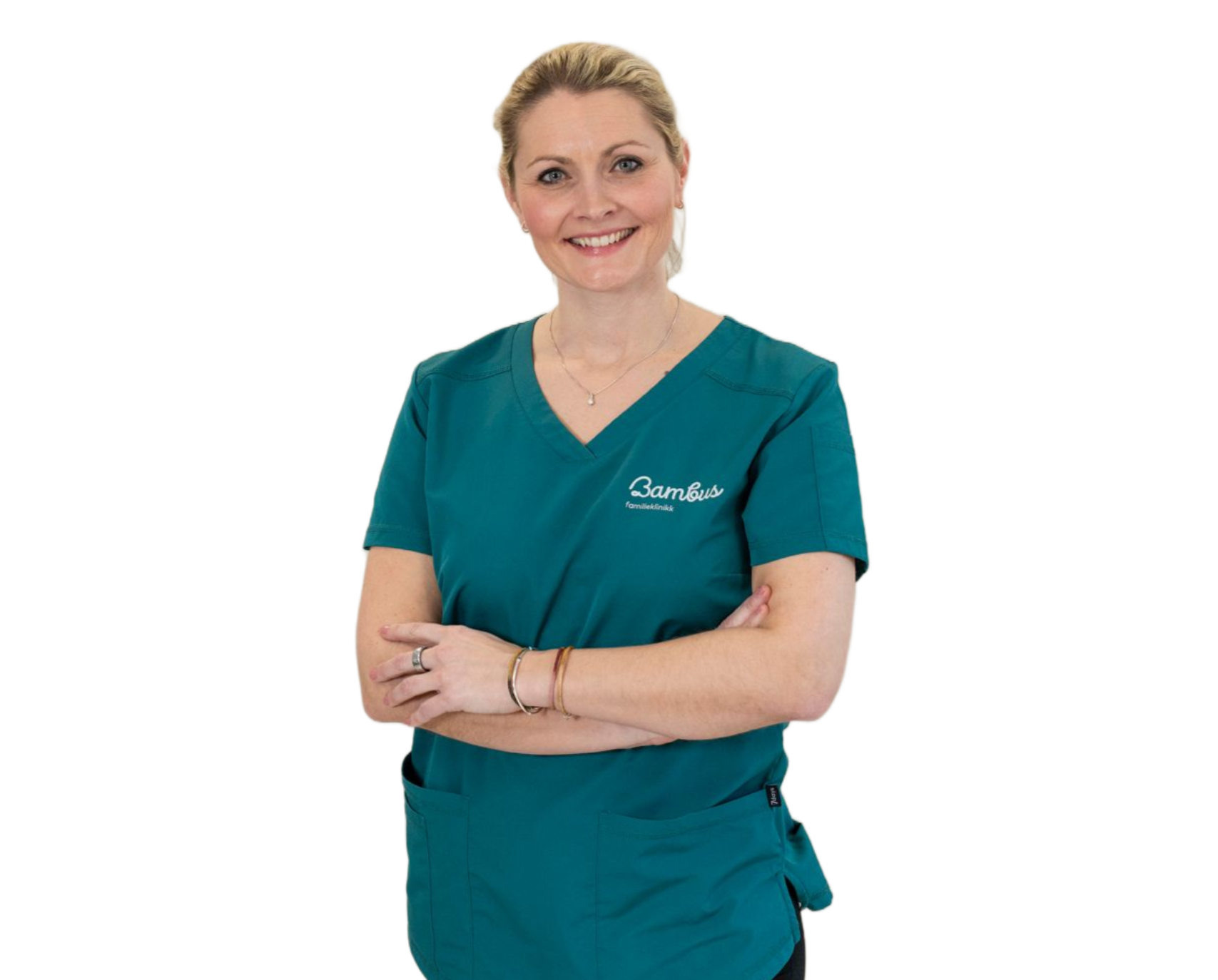 En smilende profesjonell iført en blågrønn V-hals skrubbtopp med armene i kors, mot en enkel hvit bakgrunn.