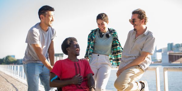 happy group of people on beach talking about life insurance