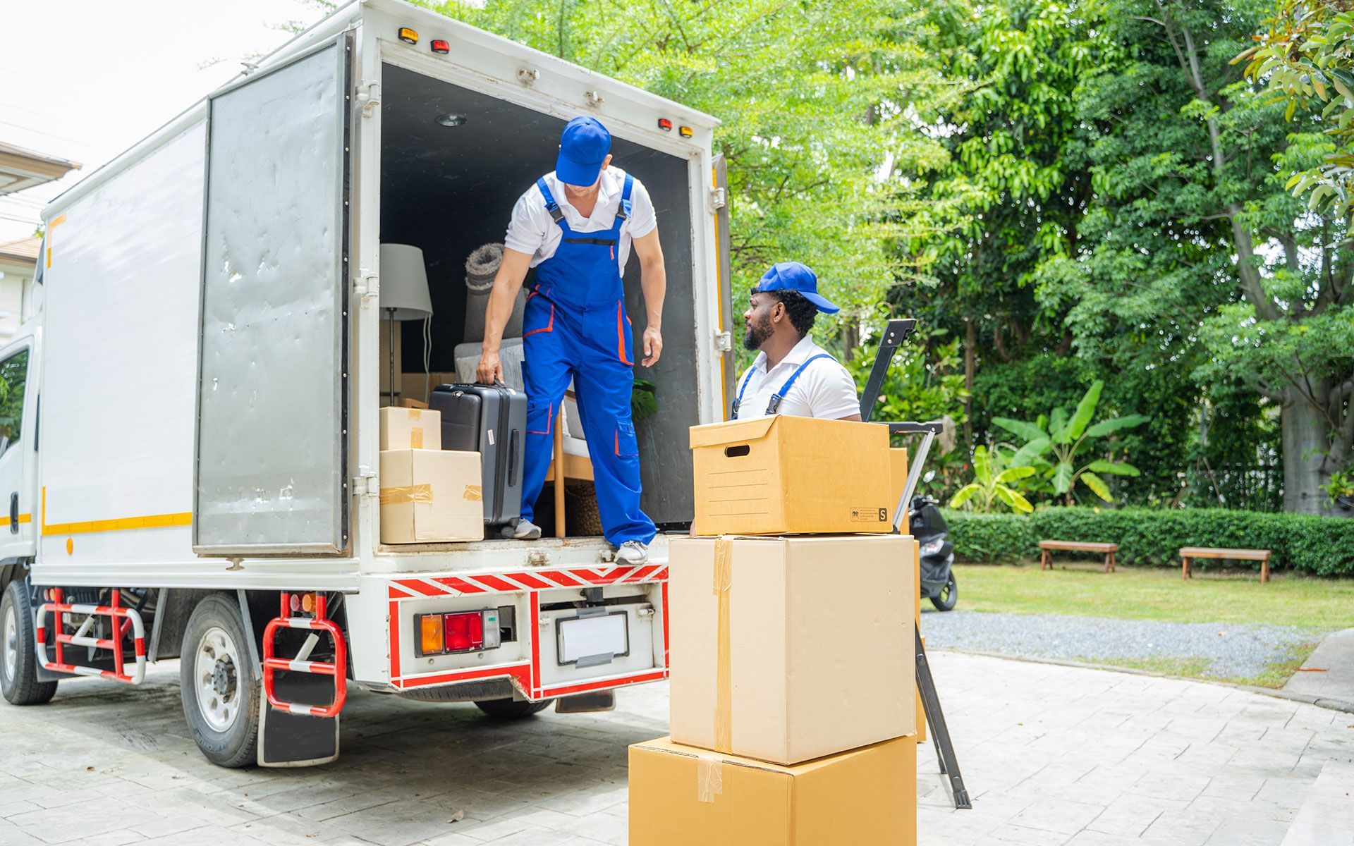 Two men are loading boxes into a moving truck.