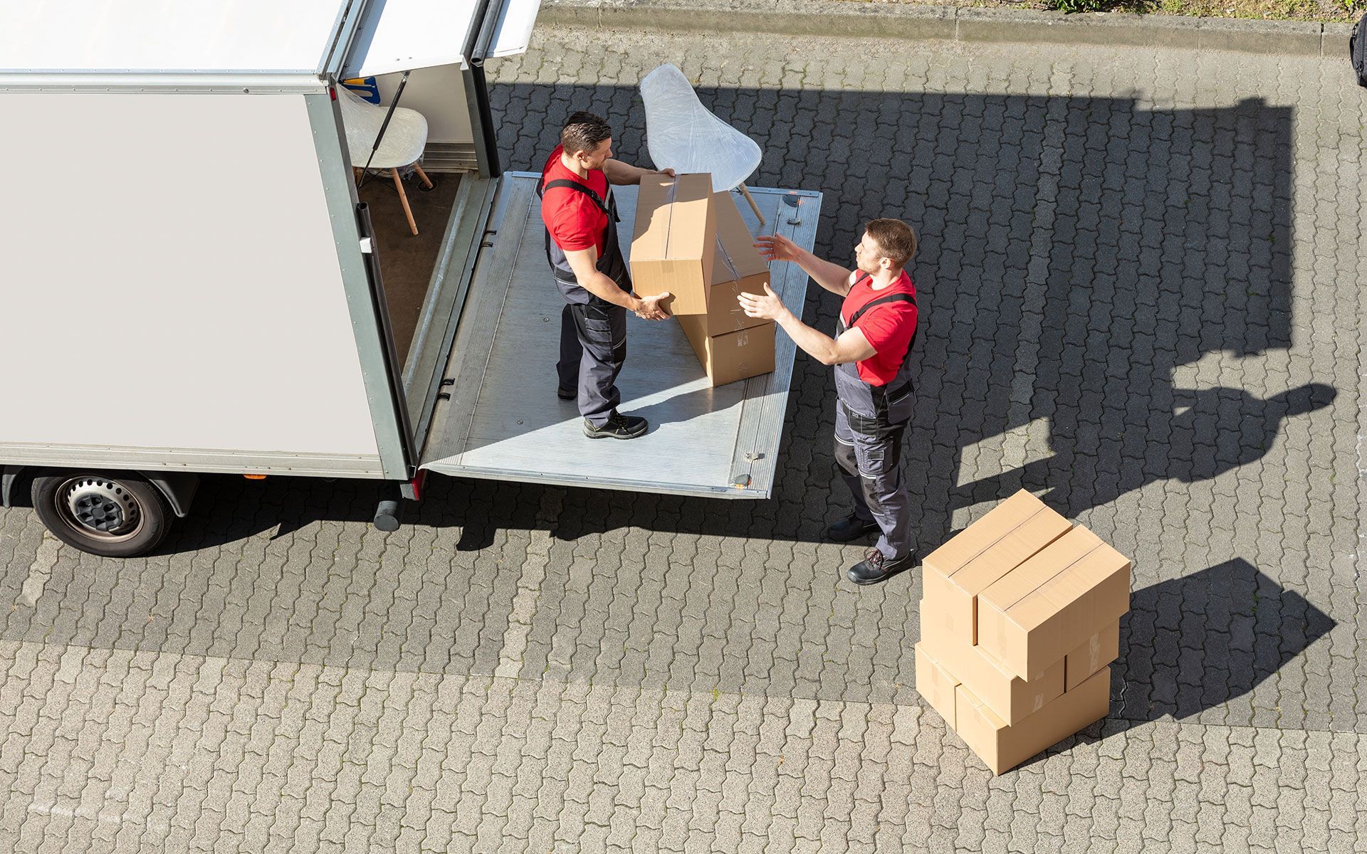 Two men are loading boxes into a truck.
