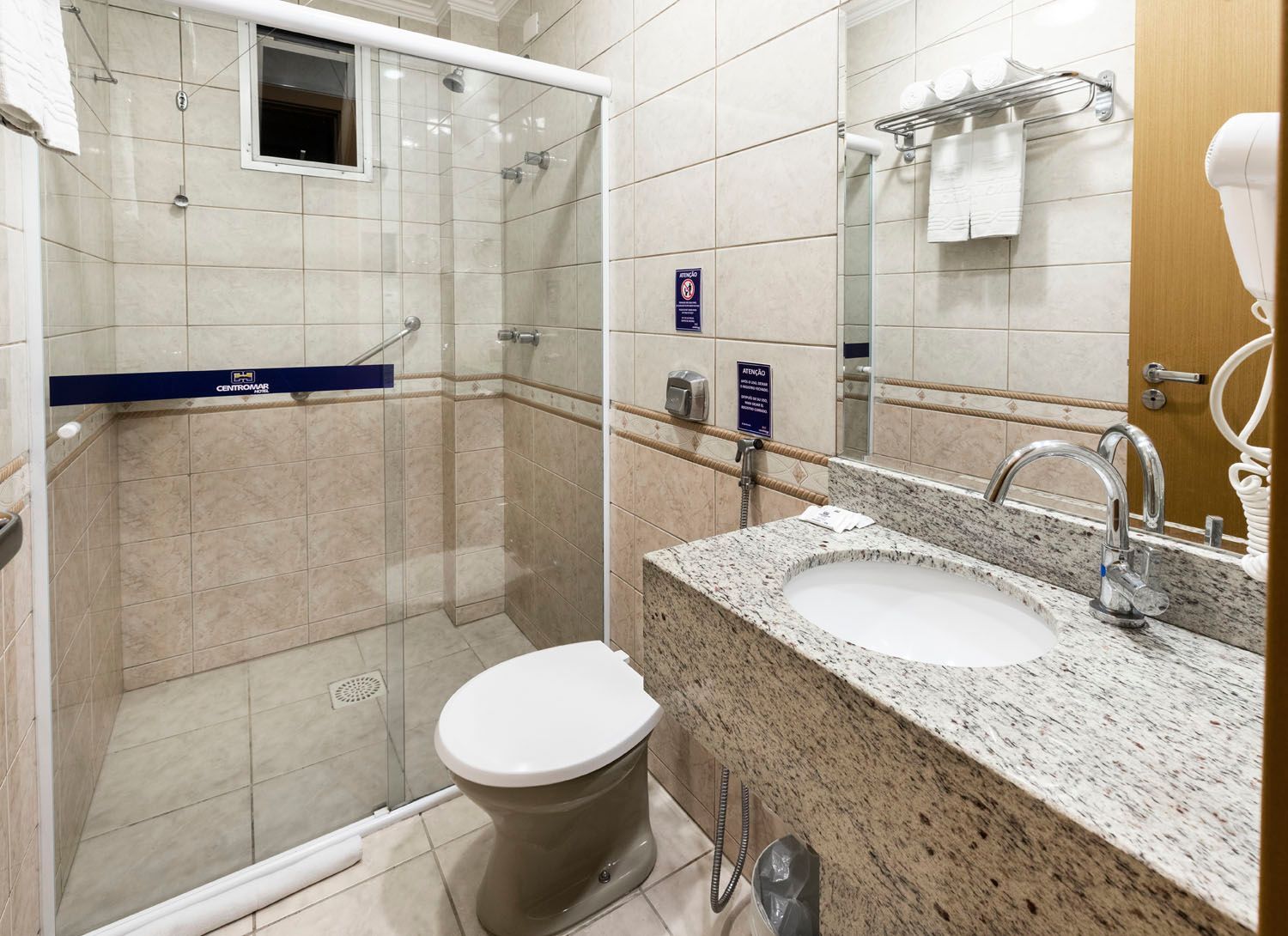 Um banheiro com vaso sanitário, pia e chuveiro.