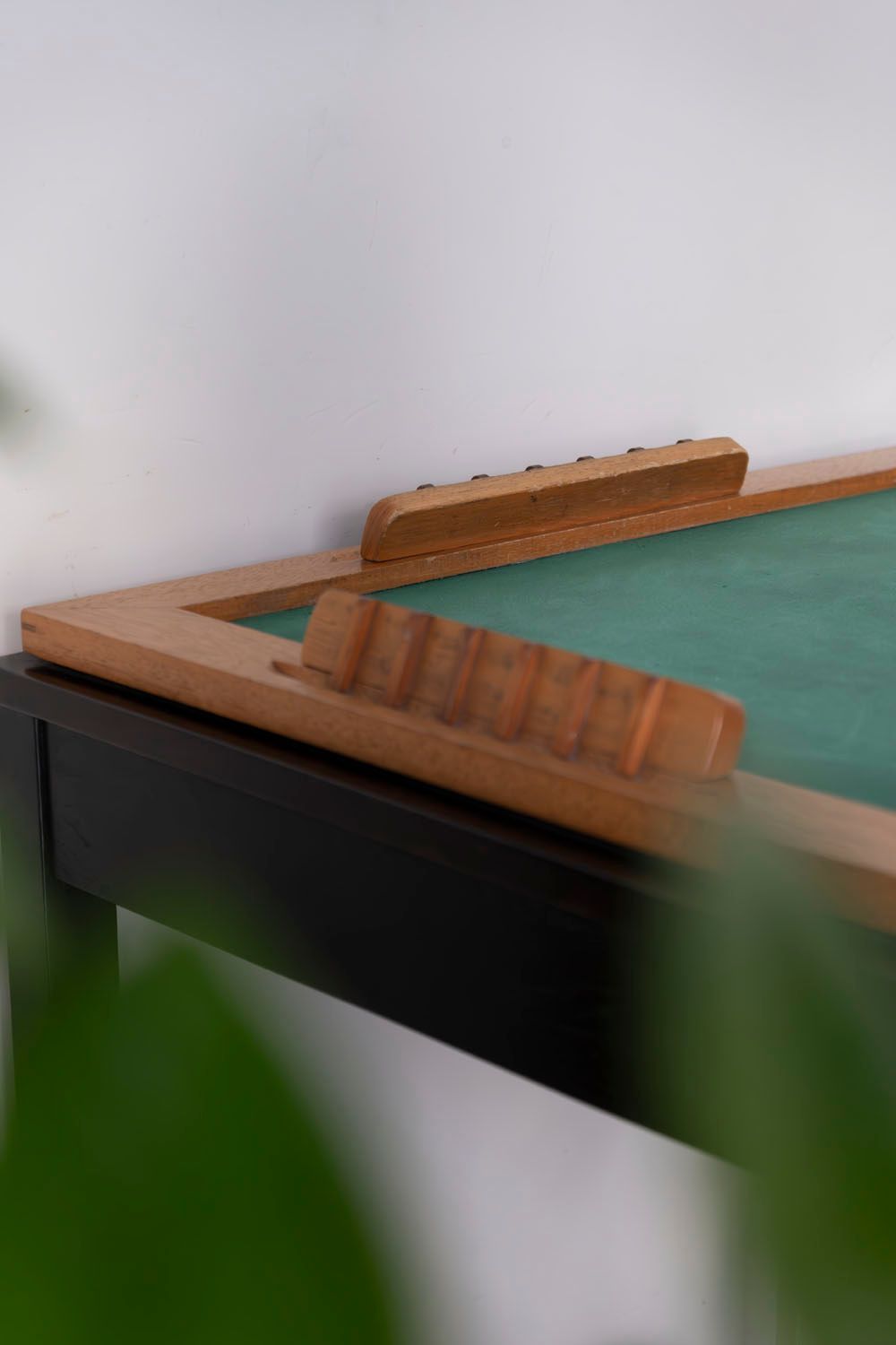 Uma mesa com uma toalha verde e uma estrutura de madeira.