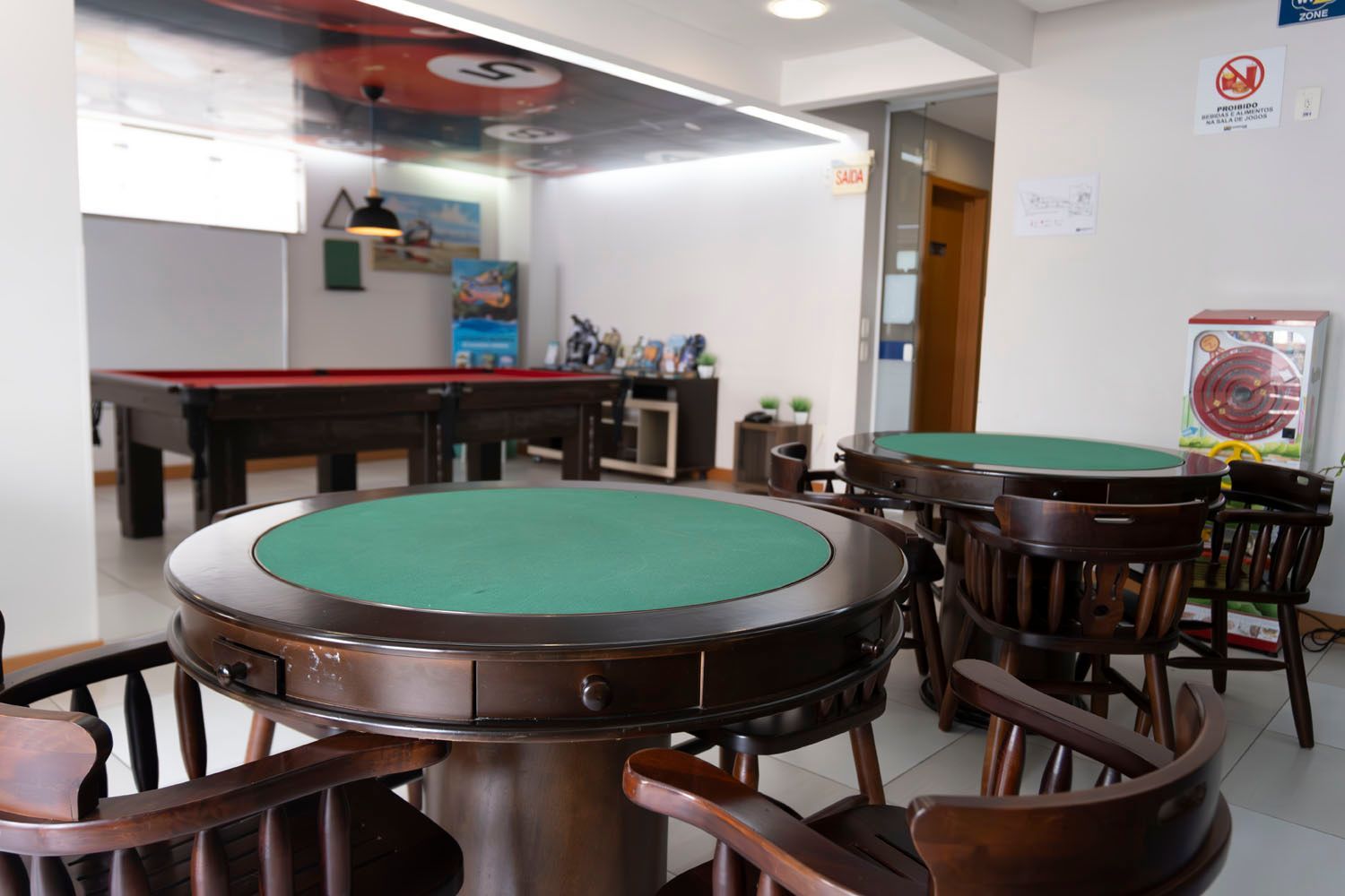 Uma sala com mesas e cadeiras e uma mesa de sinuca