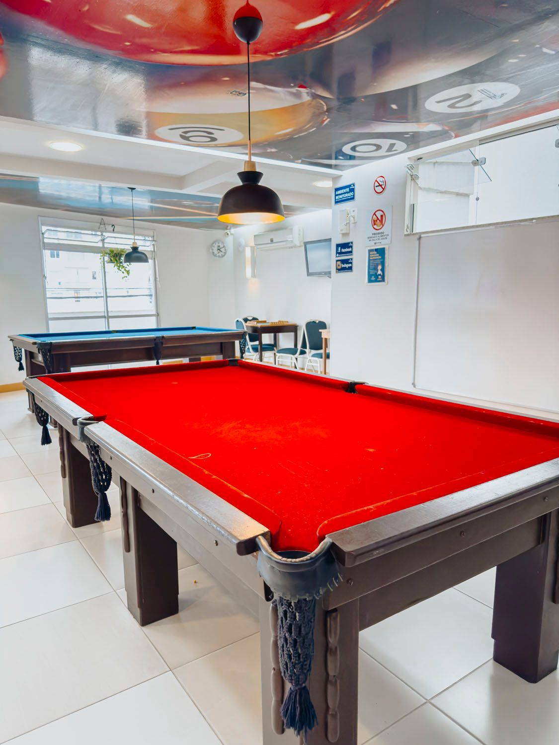 Uma mesa de sinuca com um pano vermelho em uma sala.