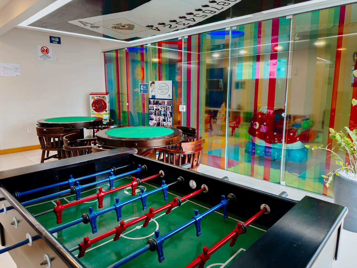 Há uma mesa de pebolim no meio da sala.
