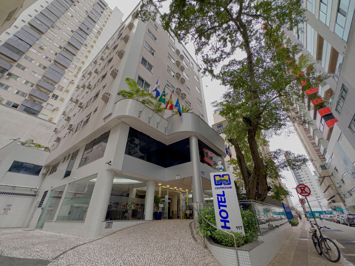 Uma bicicleta está estacionada em frente a um hotel.