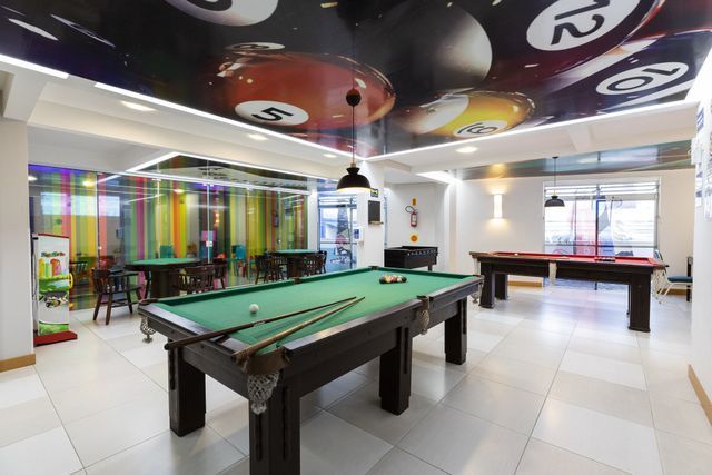 Há uma mesa de sinuca no meio da sala.