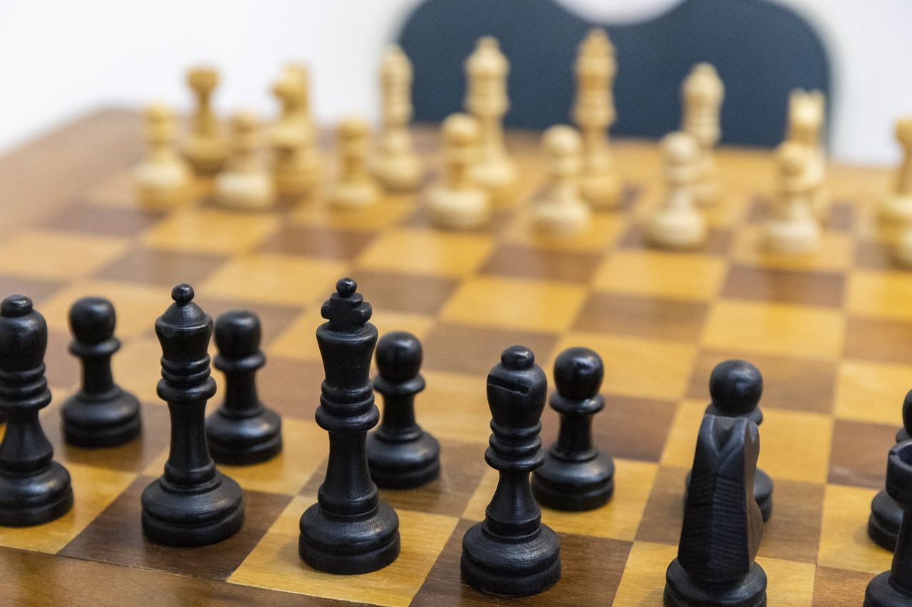 Um tabuleiro de xadrez com peças de xadrez pretas e brancas.