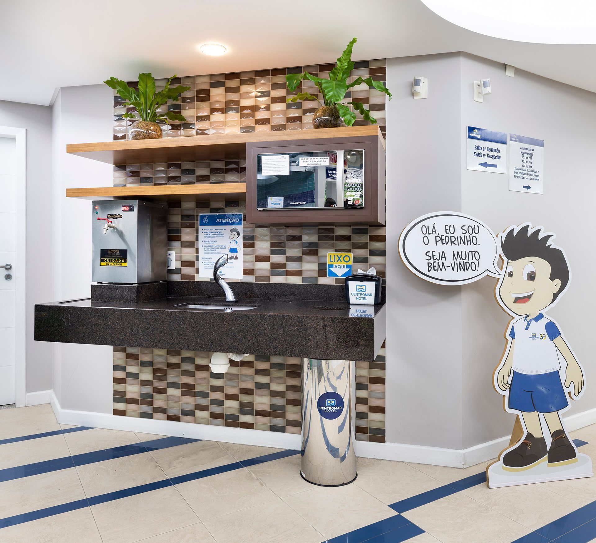 Uma sala com uma pia e um recorte de papelão de um menino