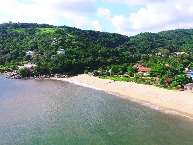 Uma vista aérea de uma praia com montanhas ao fundo