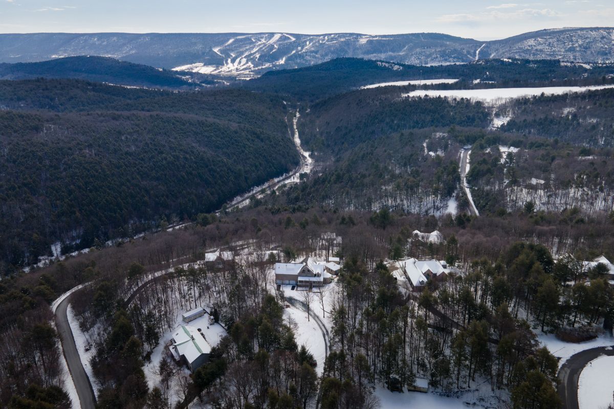 An aerial view of a snowy landscape with mountains in the background