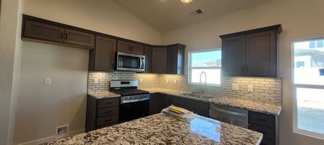 Modern kitchen with dark cabinetry and a large island at 3312 Pyrus
