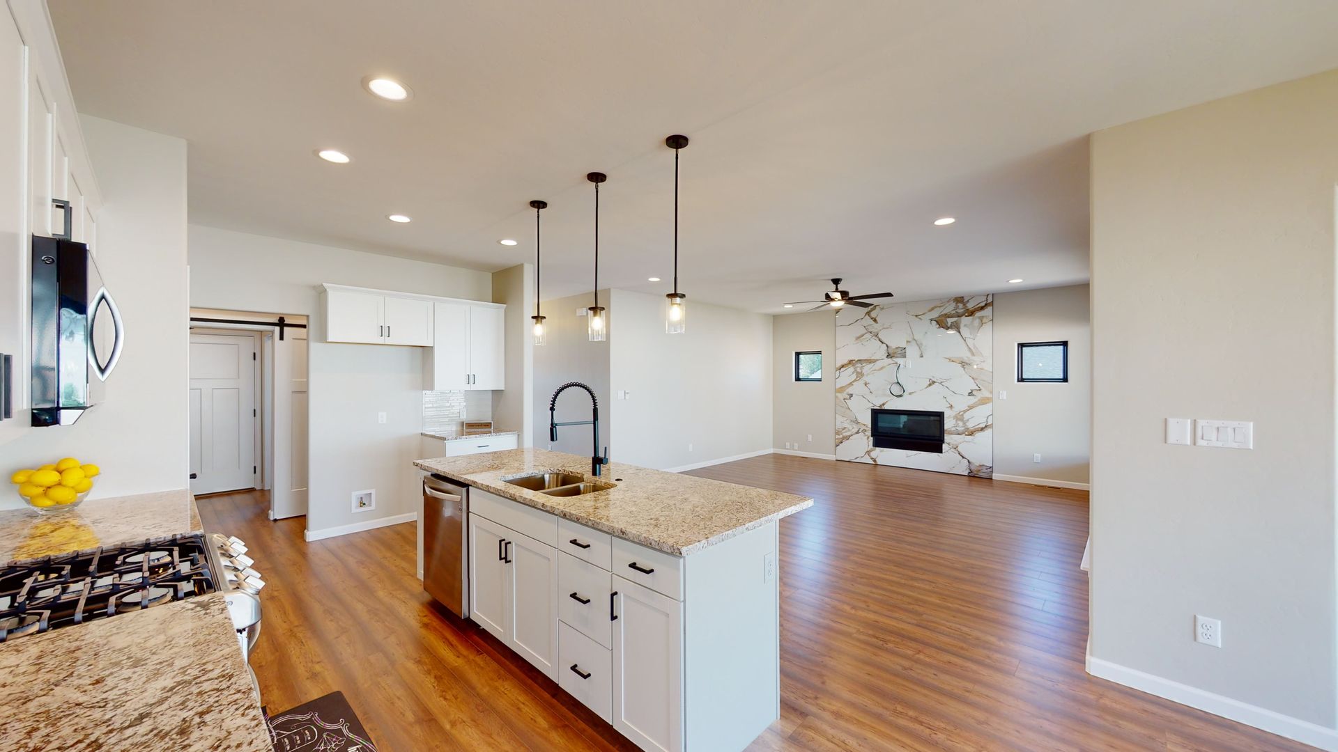 Great room with marble fireplace and granite countered kitchen.