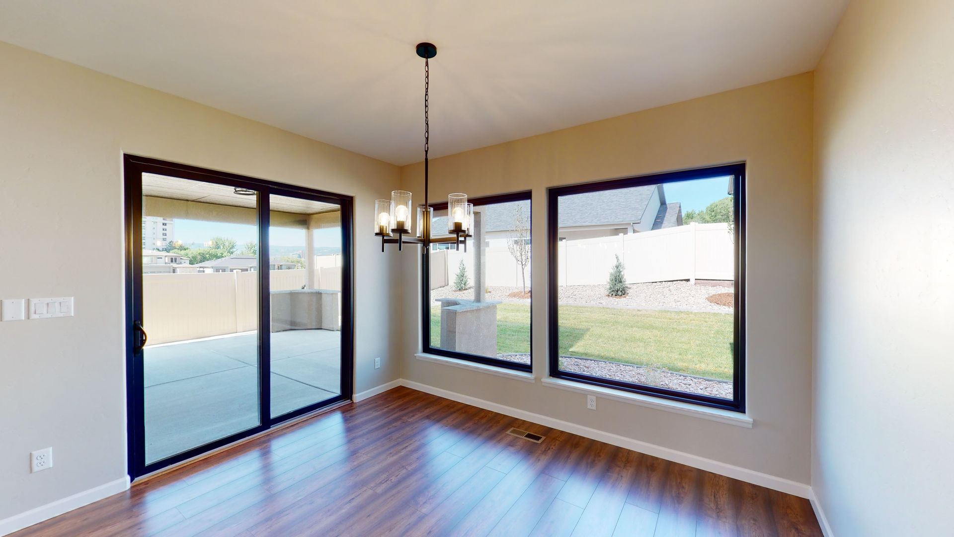 Dining room with large picture windows, sliding glass door and wood laminate  flooring.