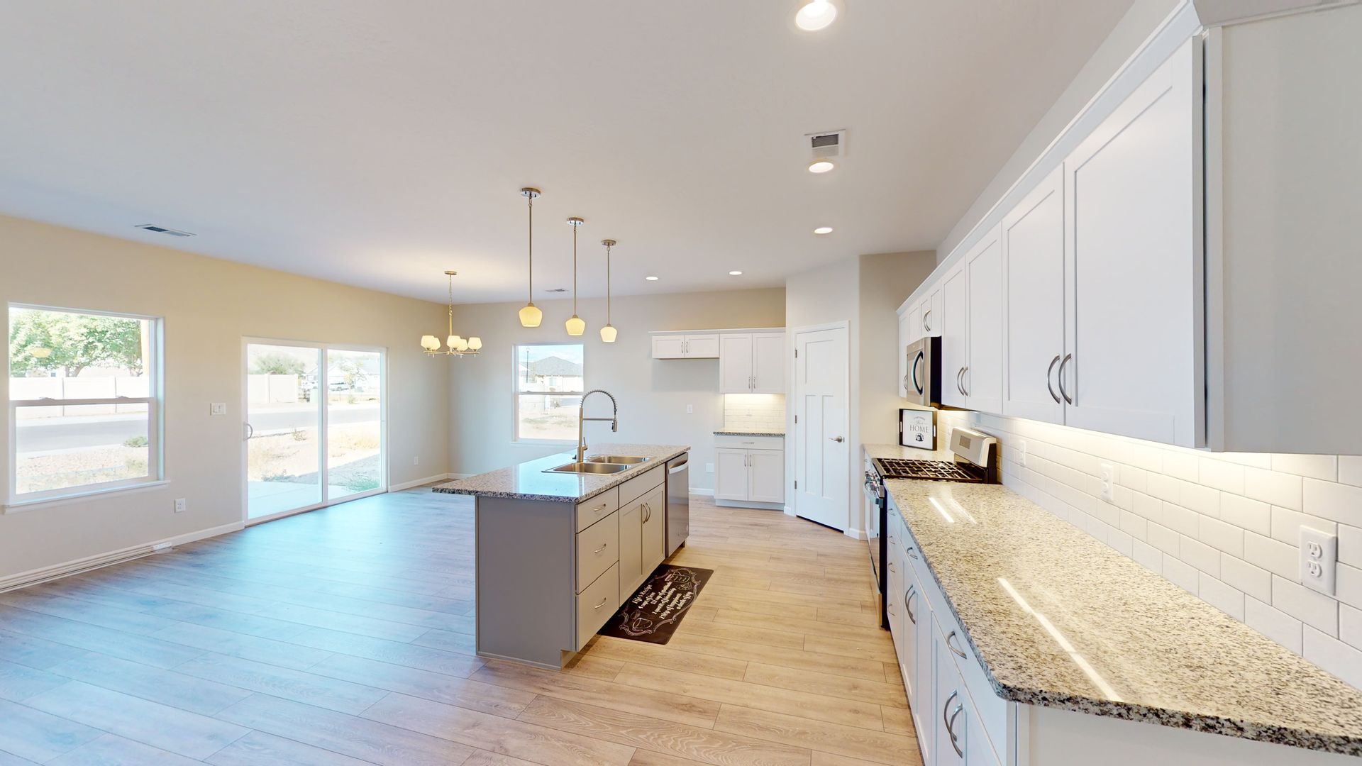 Great room with white kitchen with granite counters