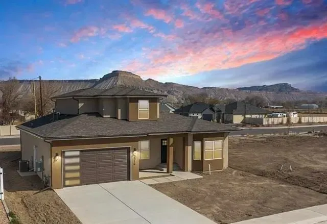 Front elevation of a modern, single-story house for sale in Grand Junction, Colorado, with a desert landscaping.