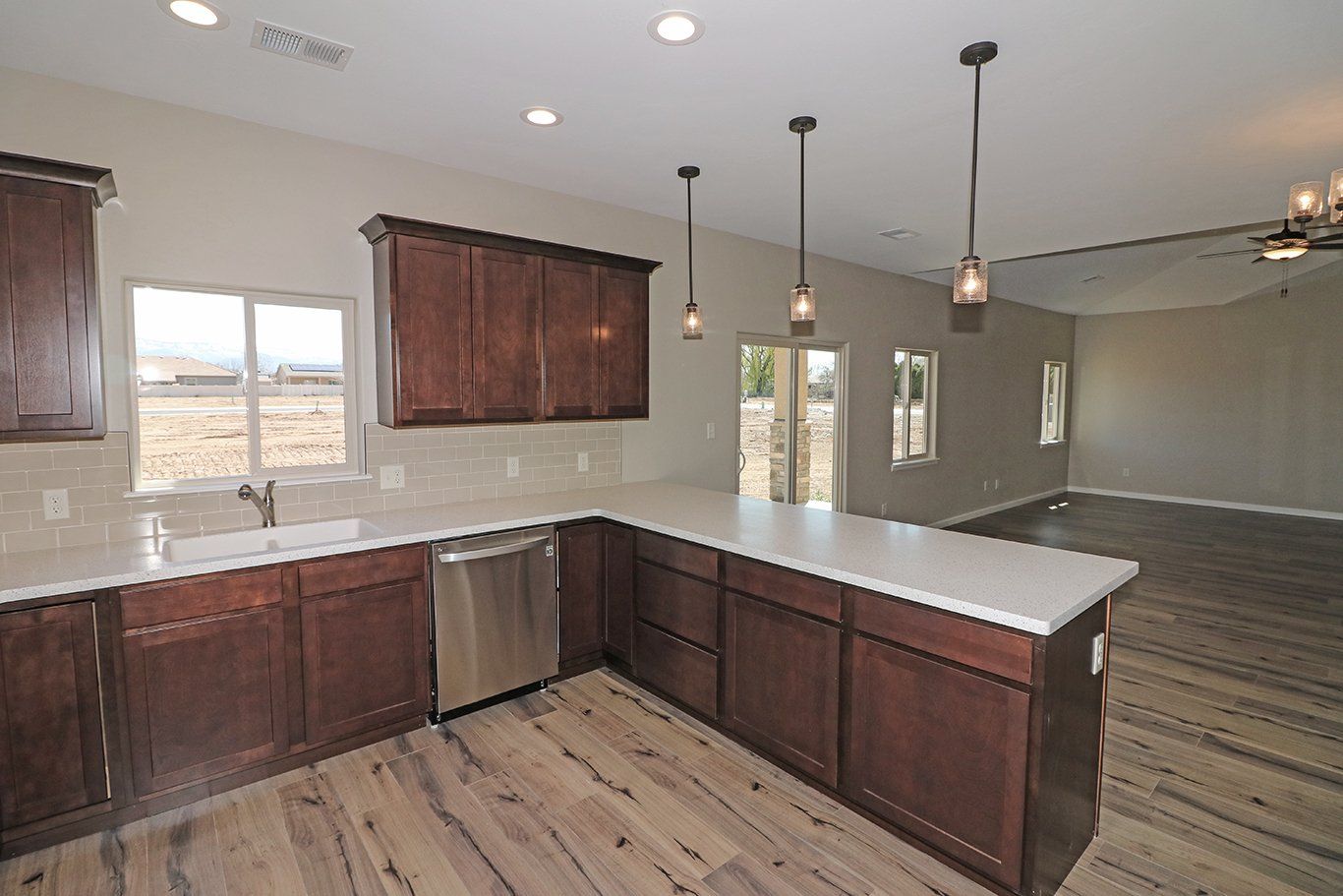 Kitchen with dark wood cabinets, quarts counters and stainless steel range