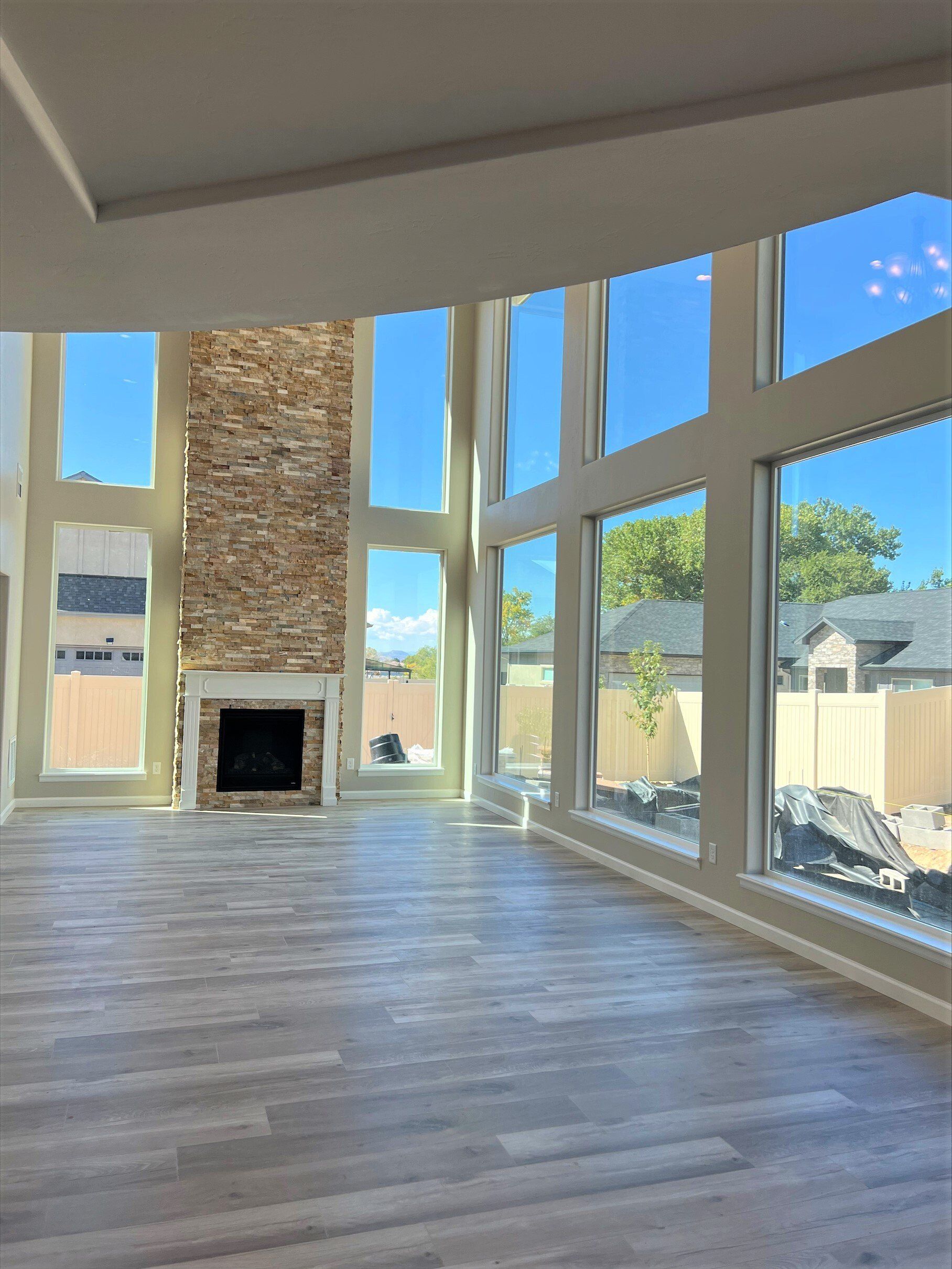 Spacious great room with vaulted ceilings, stone fireplace, and panoramic windows by Integrity Homes