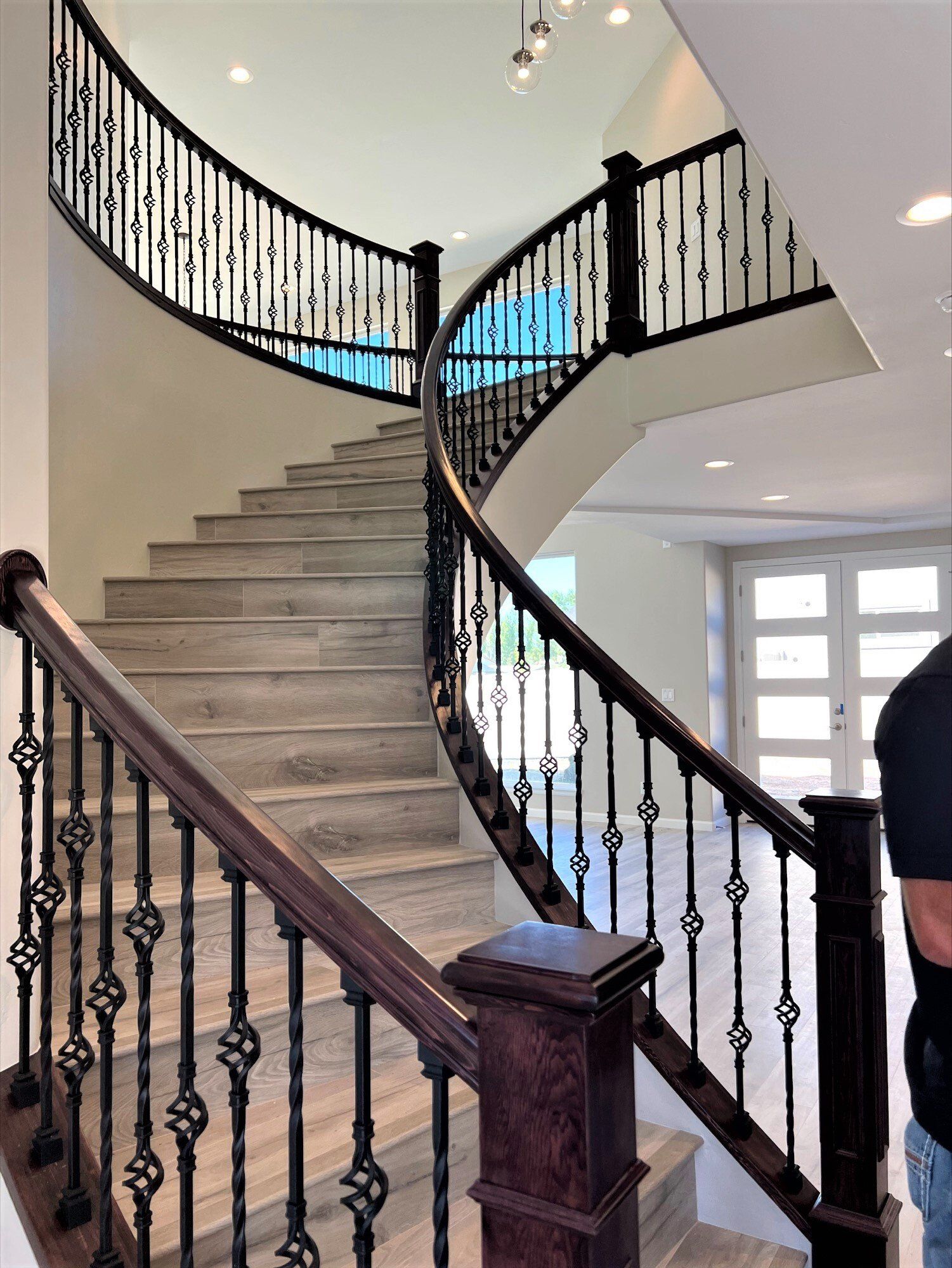 Elegant curved staircase with wood and rot iron railings