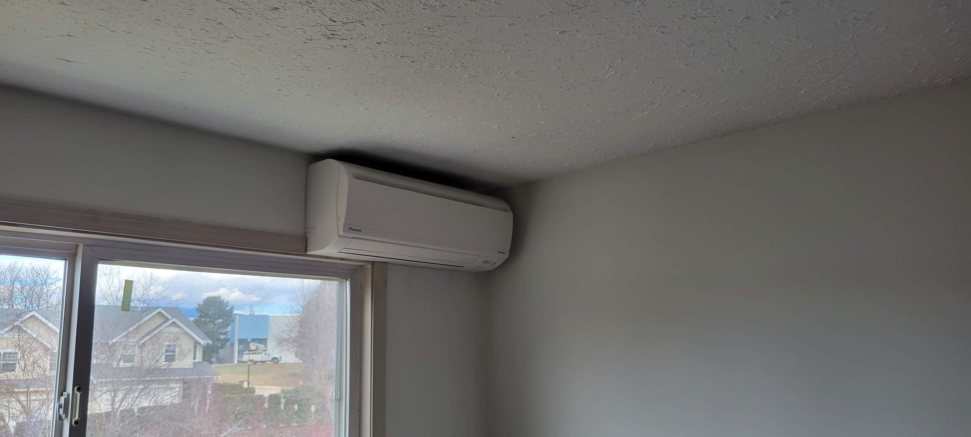 A room with a window and a ceiling fan.