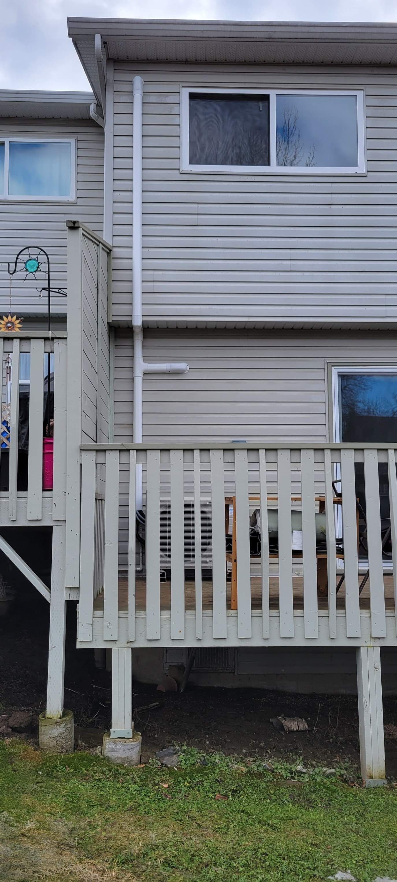 the back of a house with a deck and a dog on it .