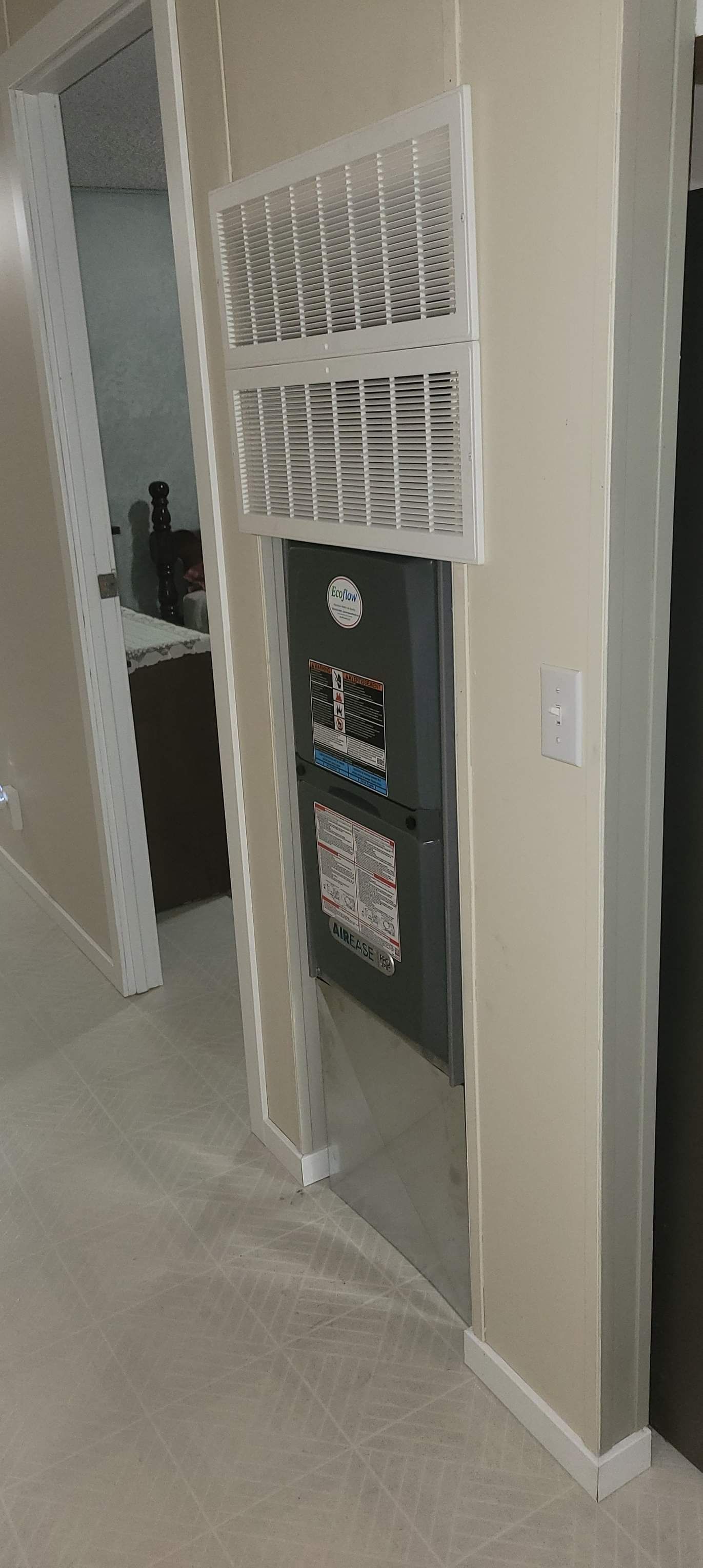 a room with a refrigerator and a fan on the wall .
