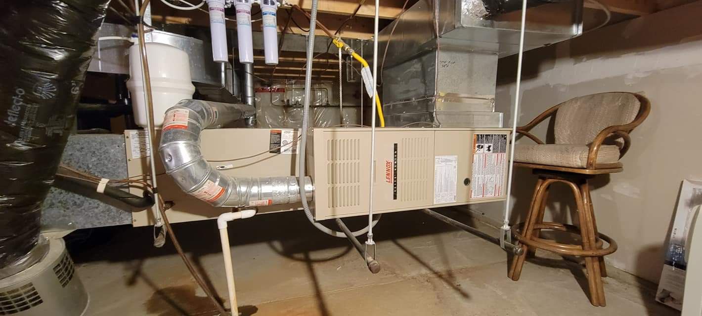 a basement with a furnace and a chair in it .