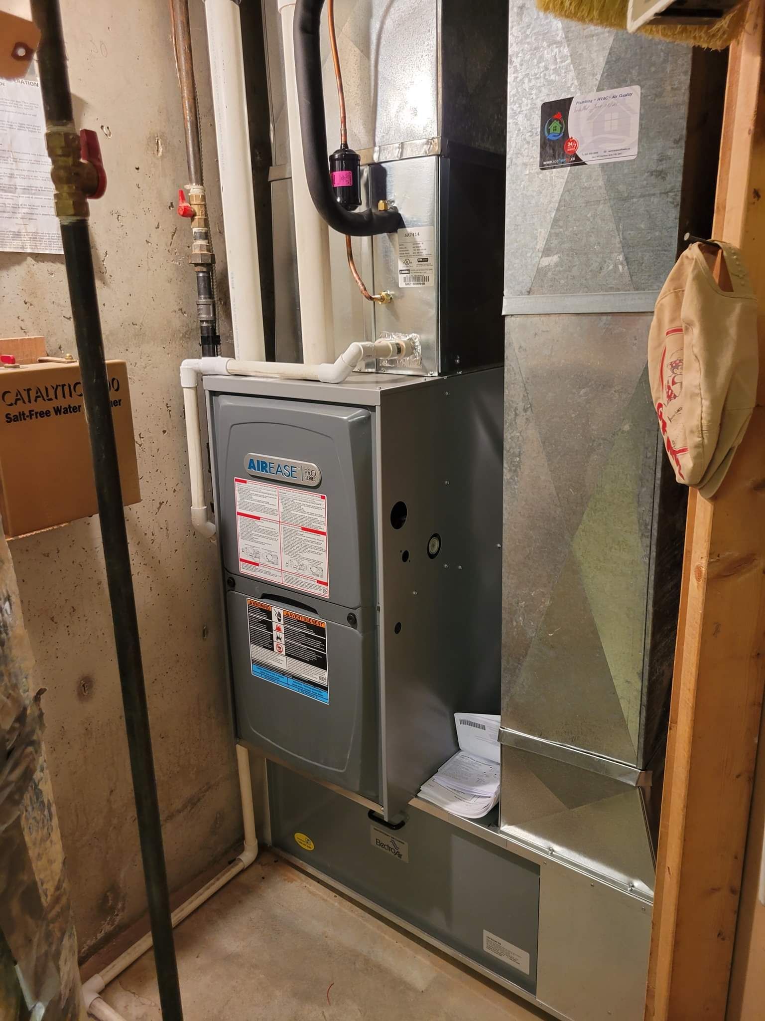 a furnace is sitting in a basement next to a wall .