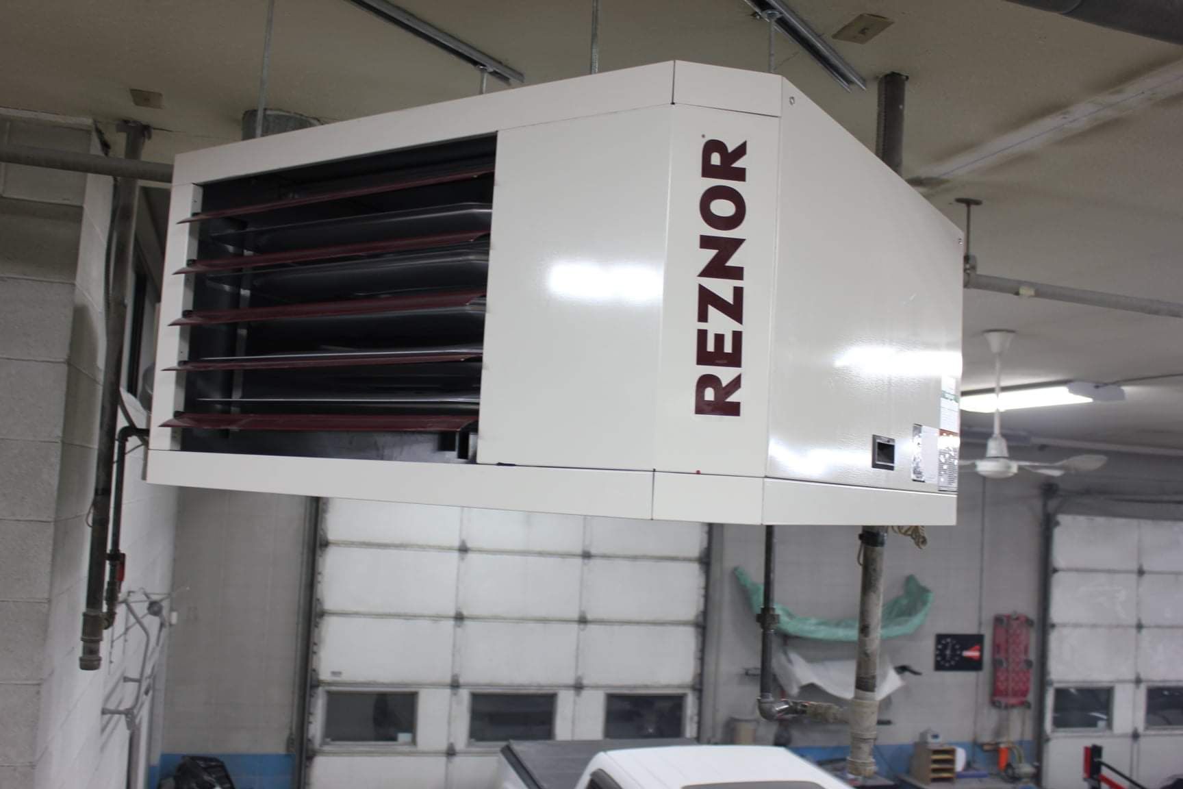 a reznor heater is hanging from the ceiling in a garage