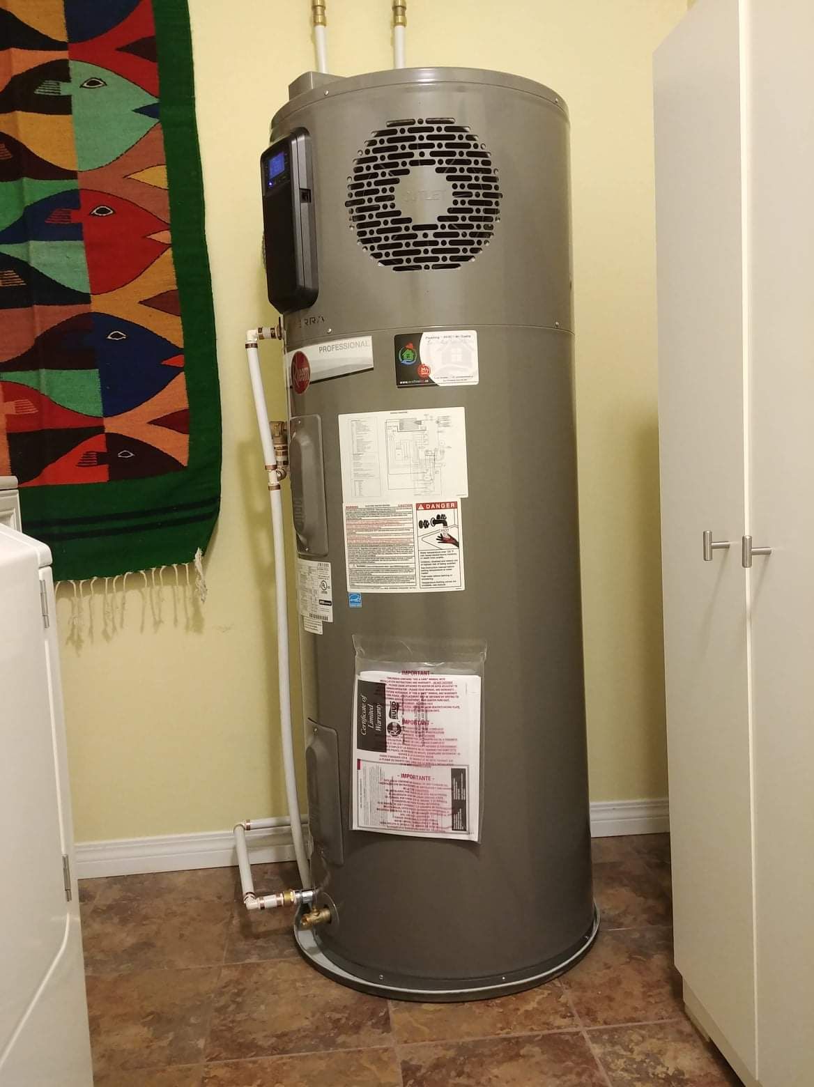 a water heater is sitting in a laundry room next to a washer and dryer