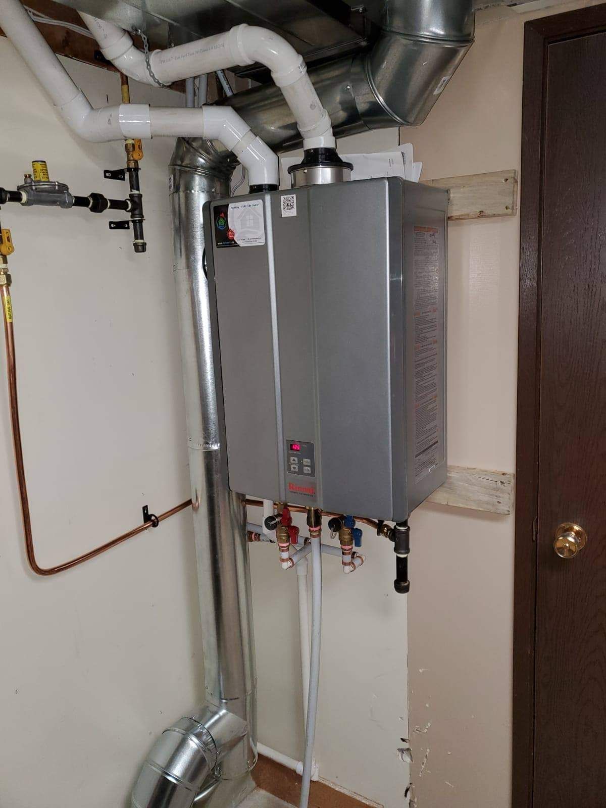 a water heater is installed in a room next to a door .